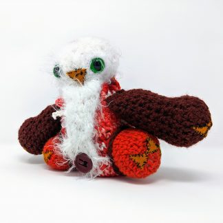 crocheted owlbear dice bag orange and brown with fuzzy white head and belly, big green eyes and button bellybutton