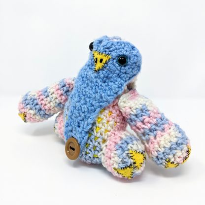 Crocheted baby owlbear dice bag pink and blue with big blue eyes and button bellybutton