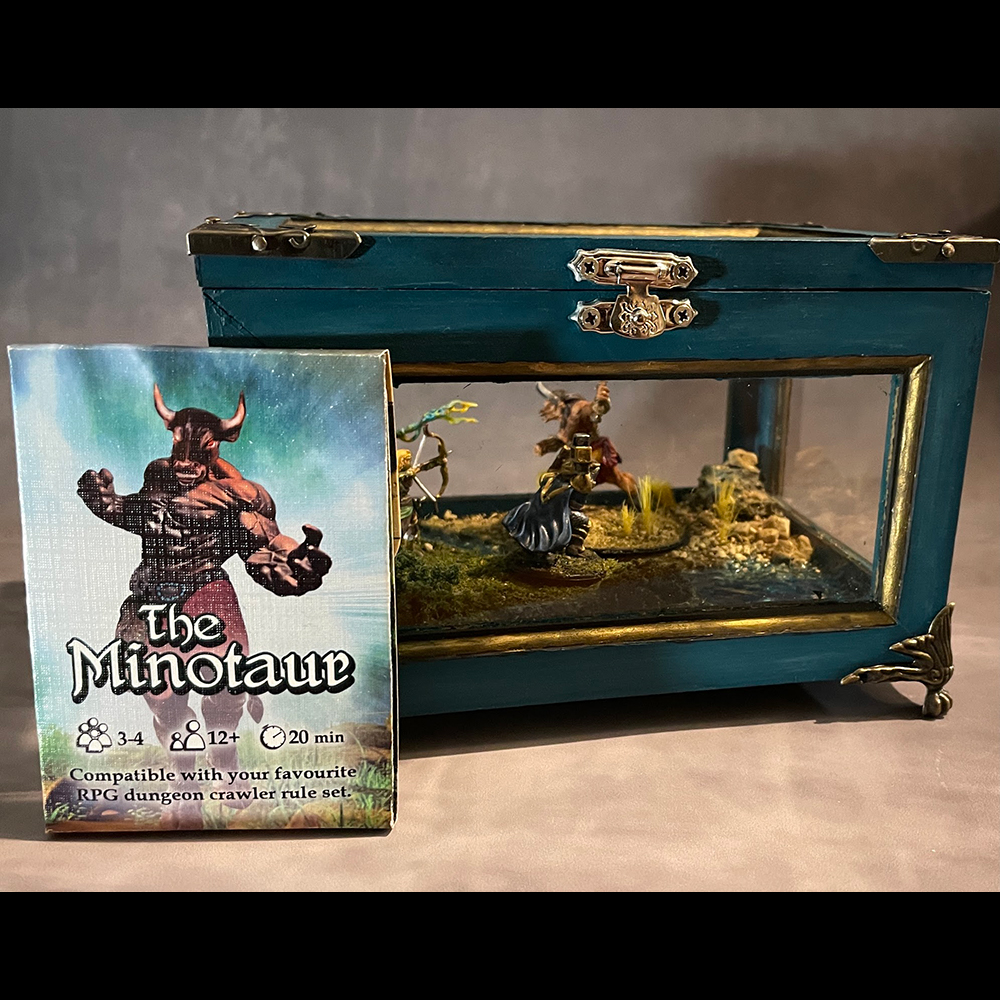Decorative wood and Glass display case containing diorama of handpainted miniatures for The Minotaur RPG one-shot, of which, the box is being displayed as well